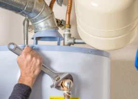 water heater repair on a blue heater on a beige walled room